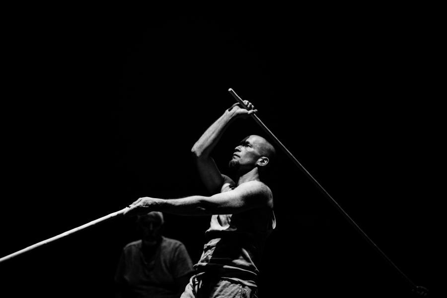 Black and white: a man dances with oars.