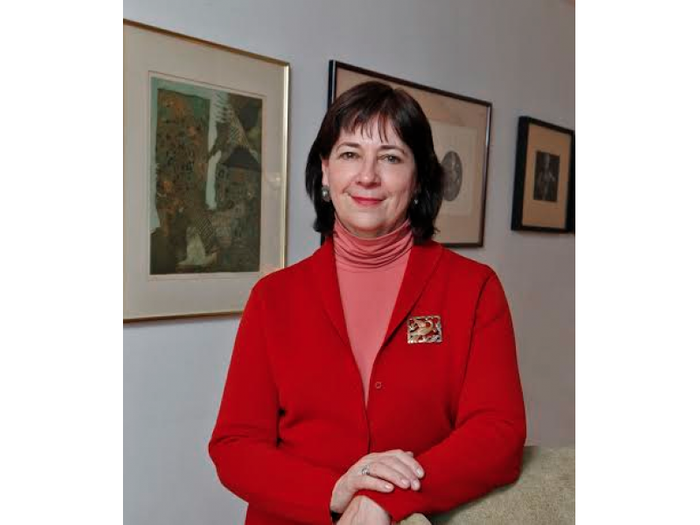 Leslie stands, smiling in a gallery space