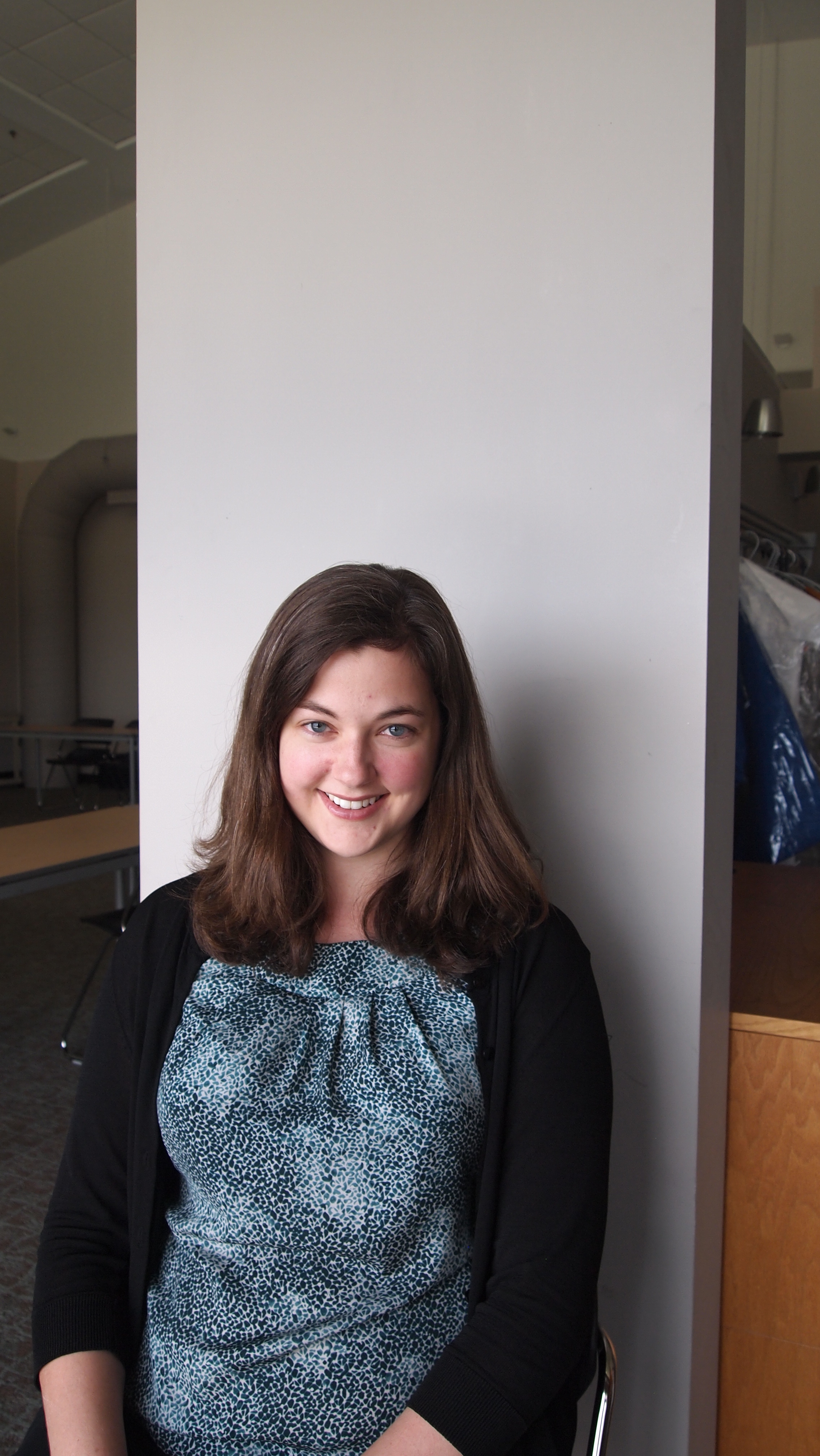 Elizabeth smiles in front of a gray background