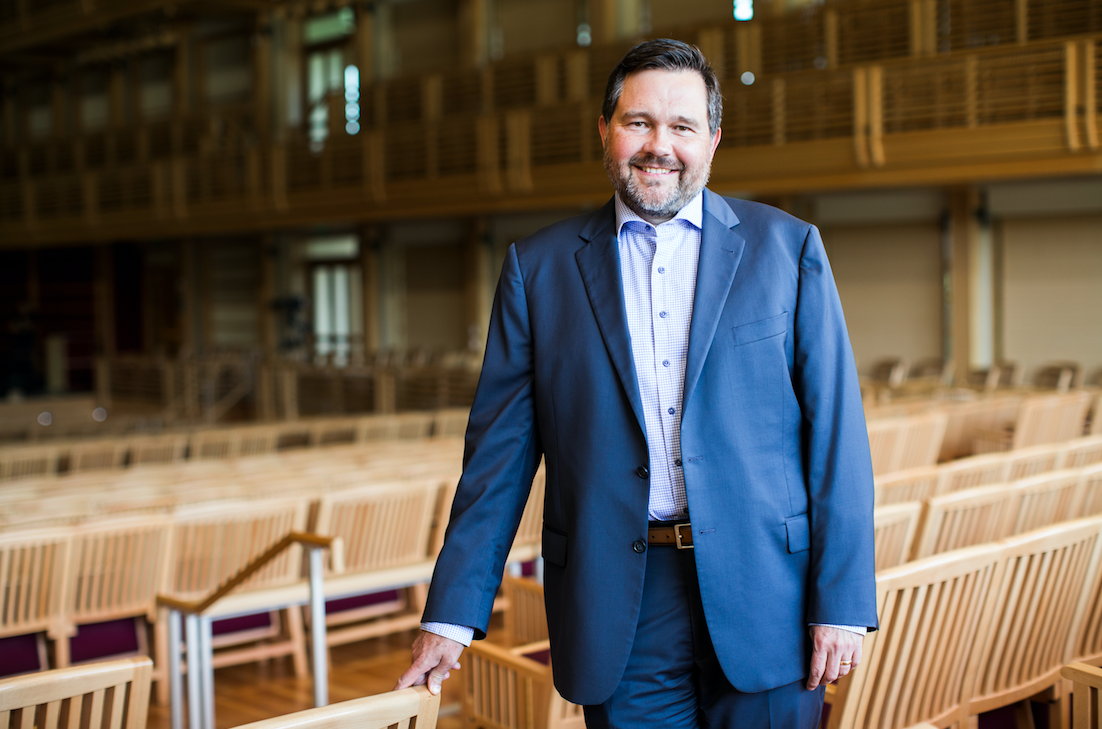 Jacob smiles in a blue jacket and button down