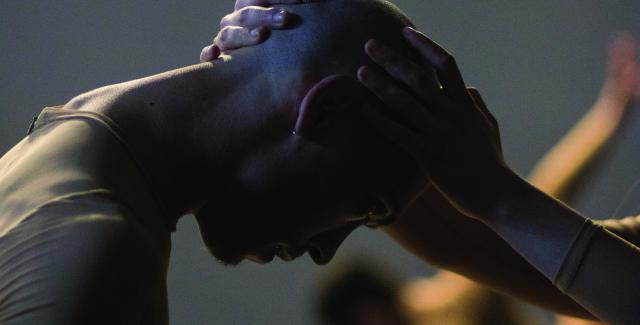 A bald person bows before another person who holds their forehead in their hands.