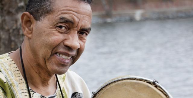 Jorge smiles with a tambourine by Jamaica Pond