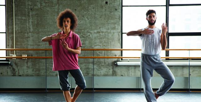 A woman and a man practice in a windowed studio.