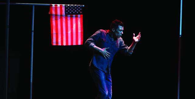 Man dances next to an American flag