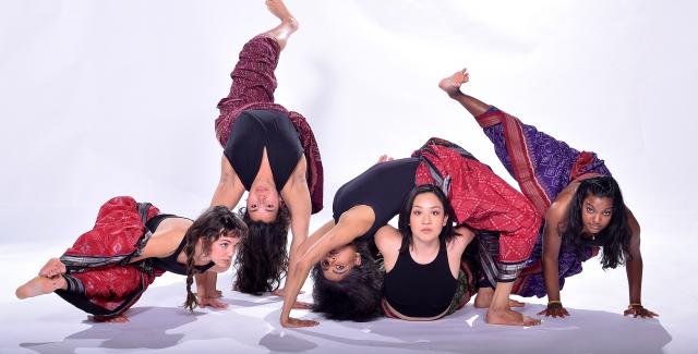 Five women dance in yoga pants along the floor