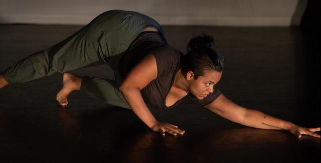 A woman crawls on the floor.
