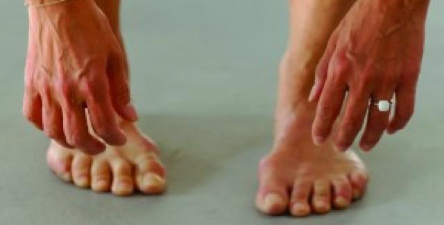 Four sets of hands hang over a pair of legs and feet.