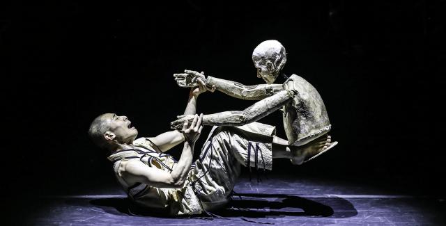 A person wrestles with a puppet.