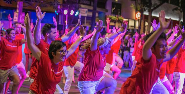Crowd in red t shirts dances