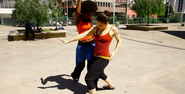 Wendy and one of her dancers perform in a concrete park. 