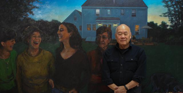 Wen-ti poses in front of one of his painting. A painting of women in the yard of a house at twilight.