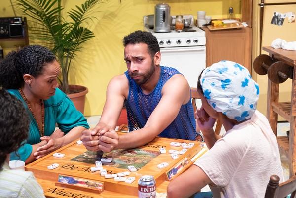 Five actors sit around a table, play a board game.
