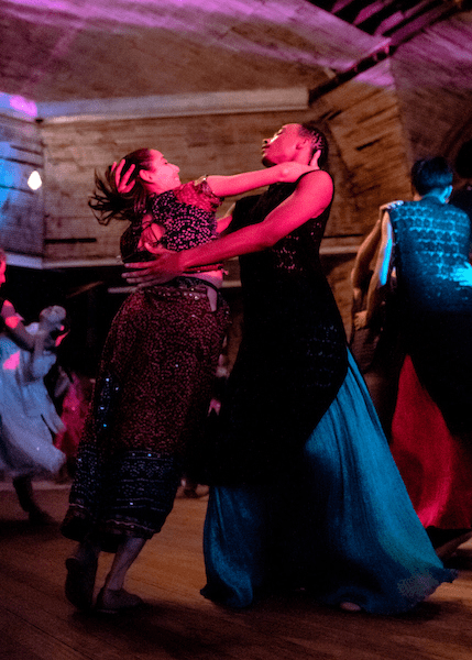 Two performers dance in each others arms.