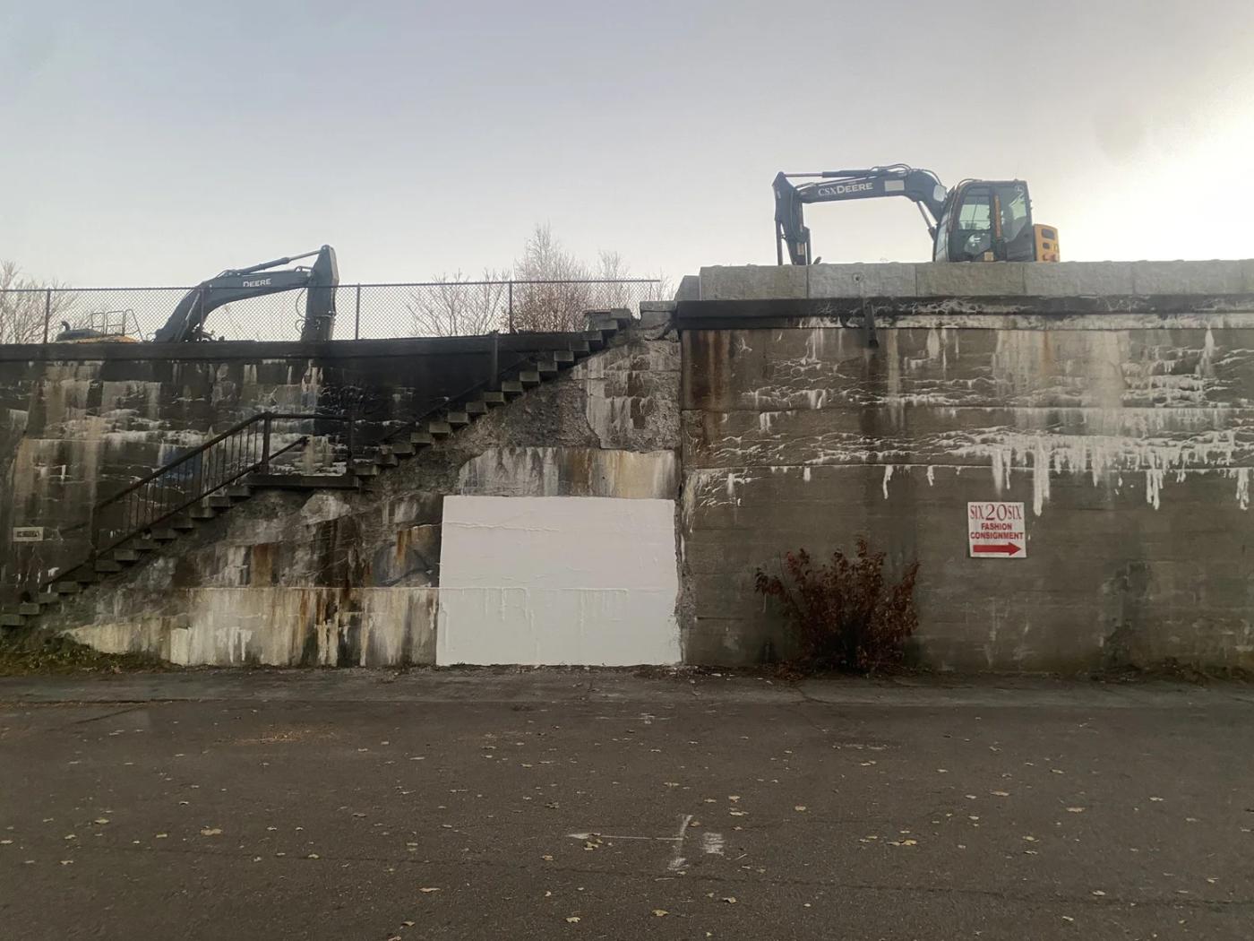 A dusty old, crumbling wall with one square painted white.