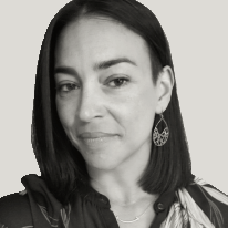 Cidhinnia has shoulder length brown hair and a teardrop earring, visible because her hair is behind her ear.