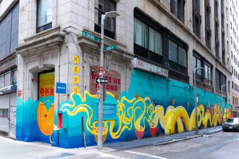 On the side of a city building, a mural of a dragon and soup.