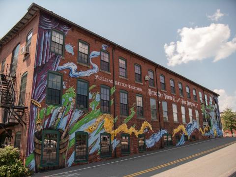 A floral mural on the side of a mill.