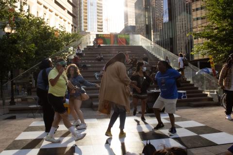 Folks dance in front of stone steps to nowhere.