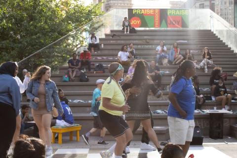 Folks dance in front of stone steps to nowhere.