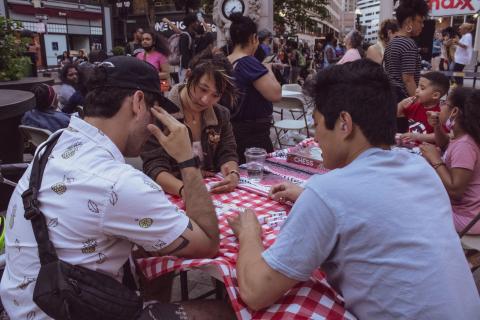 Two Asian folks and a white man play scrabble.