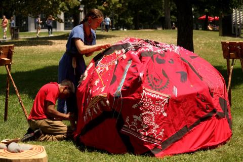 Lily and another person put together a red sweat lodge.