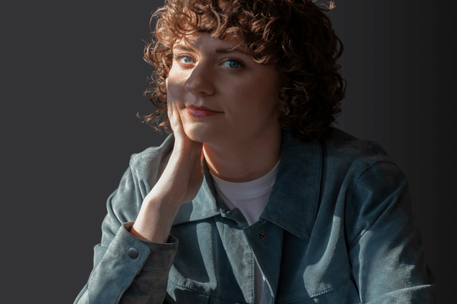 An image of a White person with curly hair and a blue jacket.