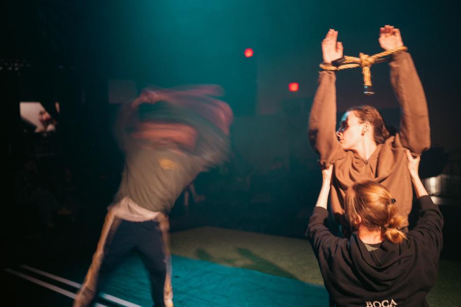 A dancer looks back at another dancer who is motion-blurred.