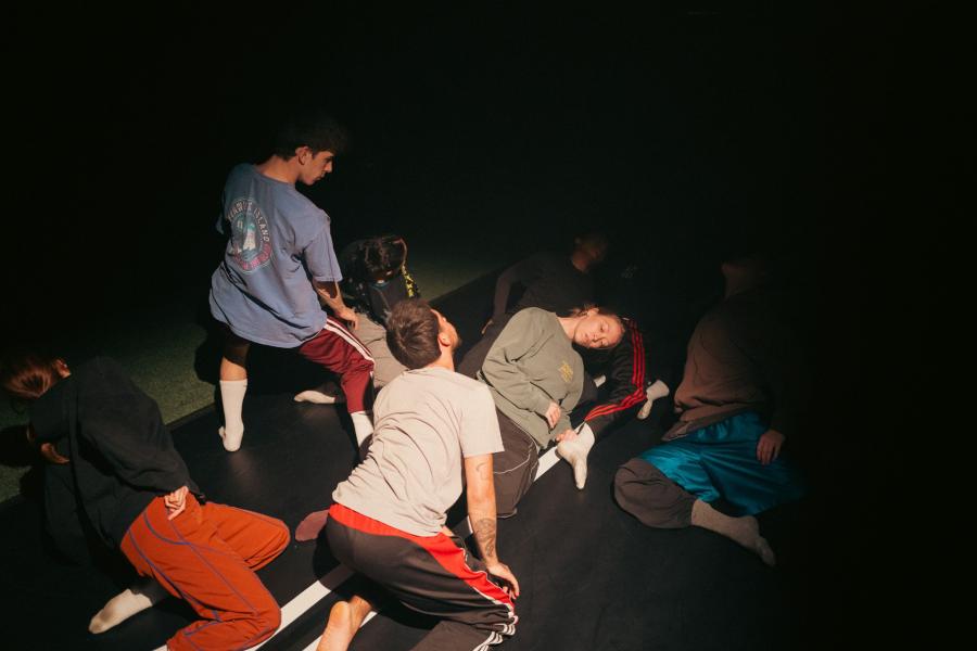In a dark room, a flash captures a group of dancers on the floor.