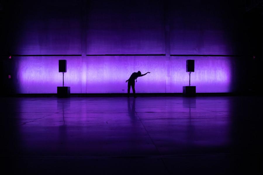 Silhouette of a dancer between two structures.