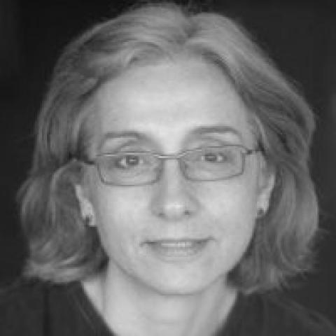 Black and white photo of a woman smiling in front of a black background