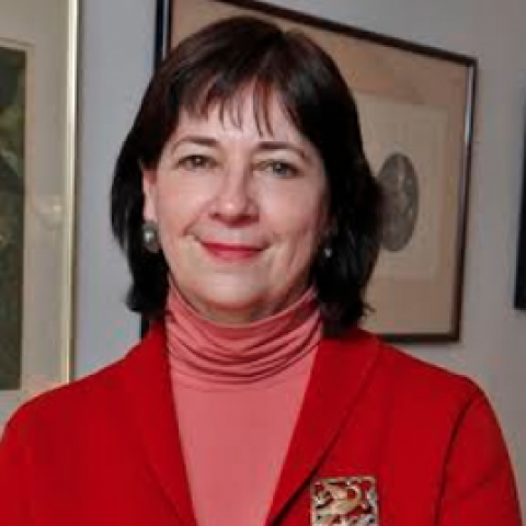 Leslie stands, smiling in a gallery space