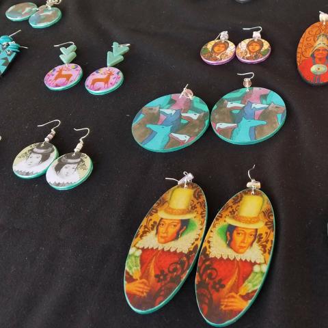 Closeup of earrings on a black table cloth.