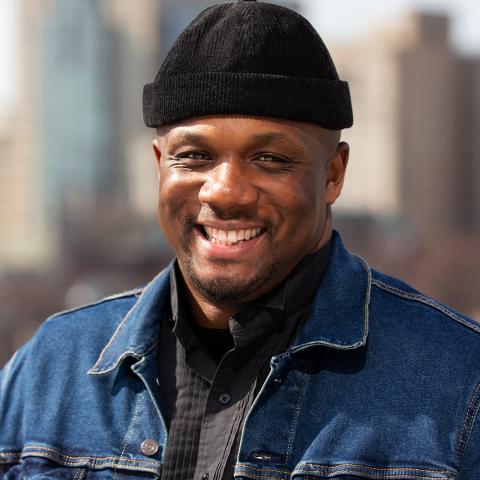 Harold wears a capless black hat and denim jacket. He is a Black person.