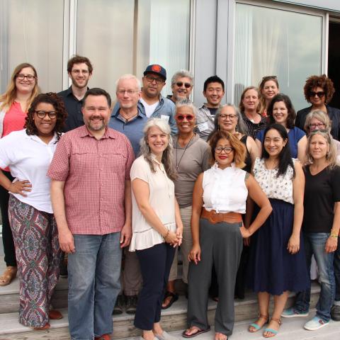 A group of people pose together on a deck.