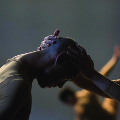 A bald person bows before another person who holds their forehead in their hands.