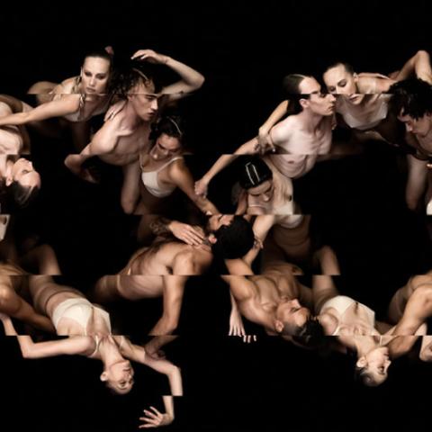 In a black space, overhead, two circles of dancers.