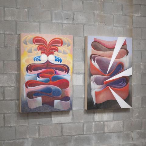Paintings of layered fabrics on a stone wall.