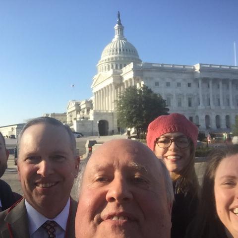 Five people smile for a selfie in front of the US Capital Building