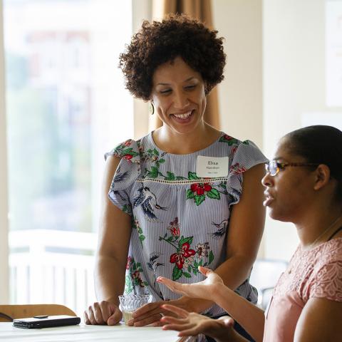 Two females talk and laugh.