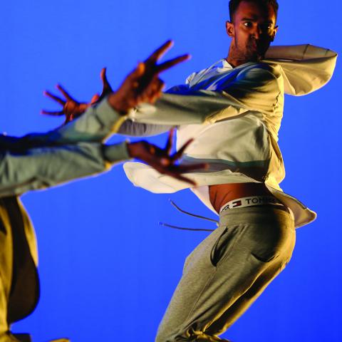 Two men vogue. One of them is jumping.