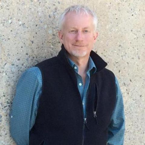 A smiling man in a fleece vest