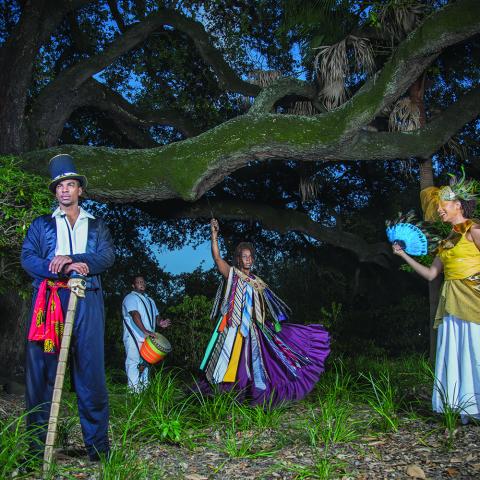 Four costumed people stand beneath an Ansemen Oak tree.