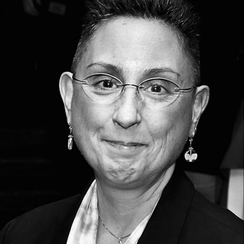 A woman with glasses and dangling earrings.