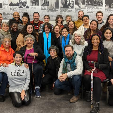 A large group of people pose indoors.