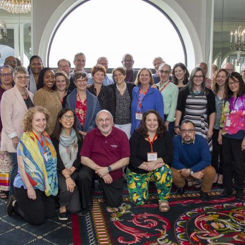 Three rows of NEFA staff and board pose for a group photo.