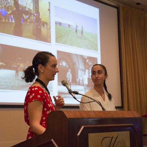 Two women give a presentation from behind a podium.