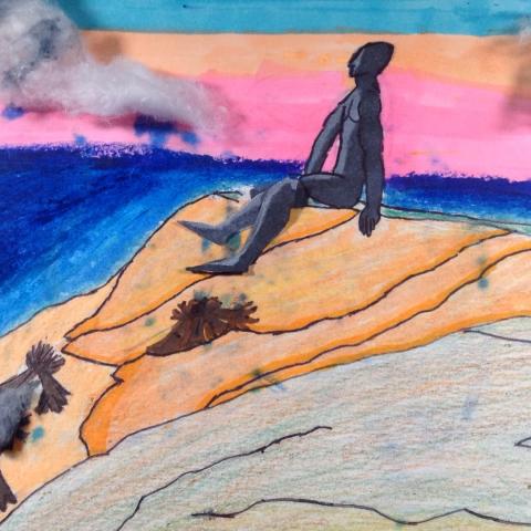 A giant sits at the edge of the ocean.
