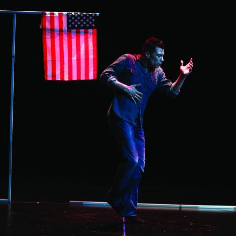 Man dances next to an American flag