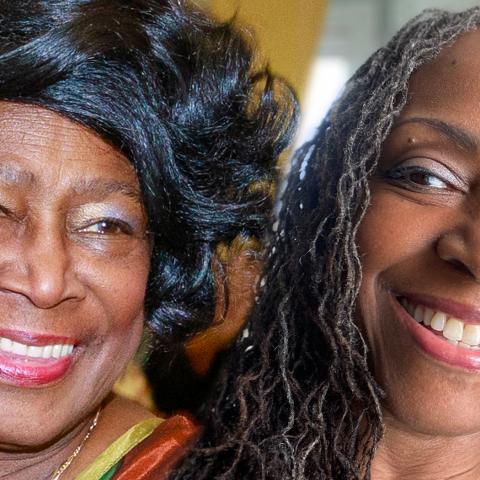 Rosemary and Ekua smile. Rosemary is a Black woman with a short, black bob and Ekua is a Black woman with long, grey braids.