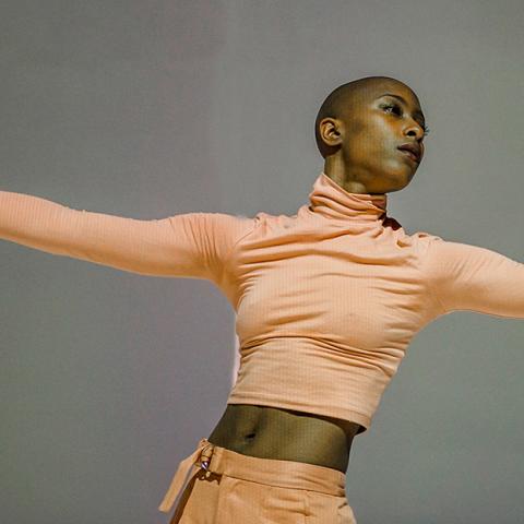 Image of a woman wearing peach clothing with arms outstretched